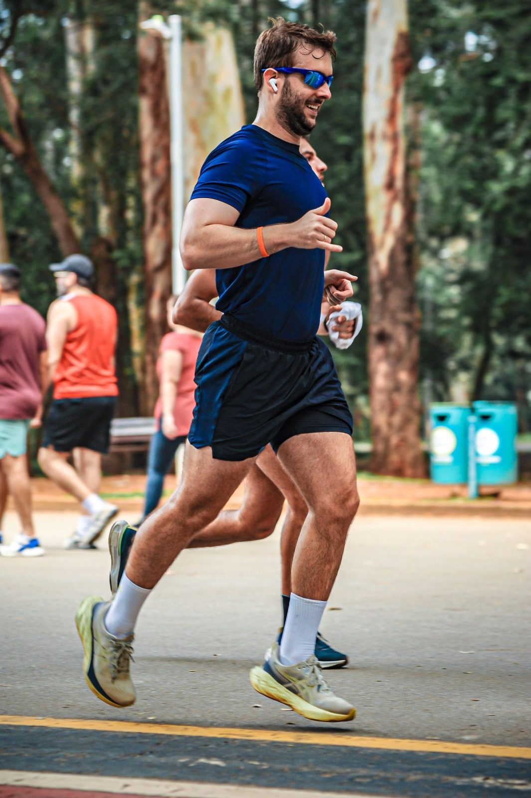 Dr. Juan Sasseron correndo num parque, de camiseta azul-marinho